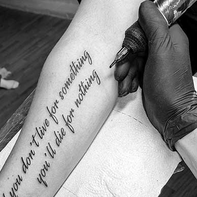 Text tatuering i svartvitt – namn och citat på arm – Joakim Tattoo Kungälv