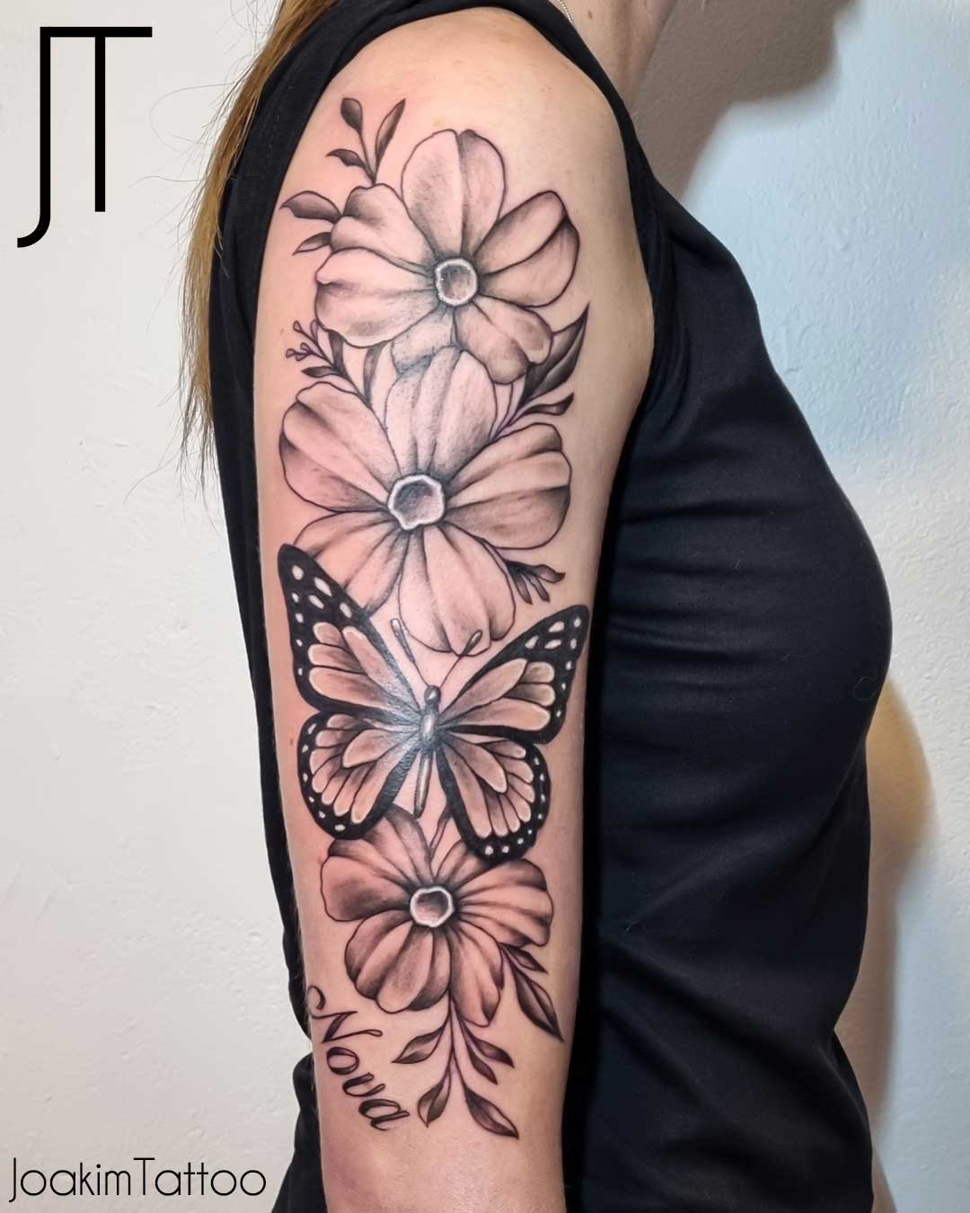 Blom tatuering med fjäril på överarmen - Kungälv